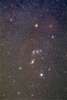 The red-orange star Betelgeuse (upper middle) contrasts with the blue-white stars of the constellation Orion